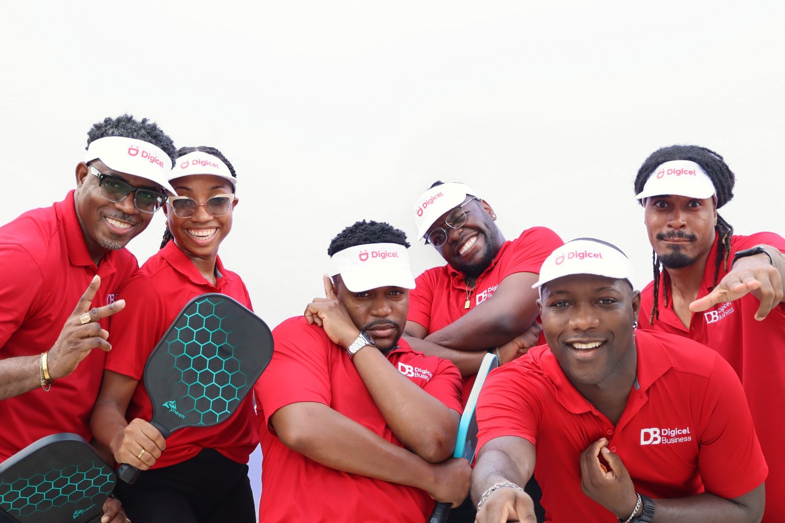 A corporate team posing with pickleball paddles